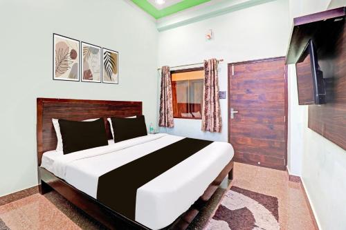 TapovanHotel O Prakash Residency的一间卧室设有一张大床和一扇木门