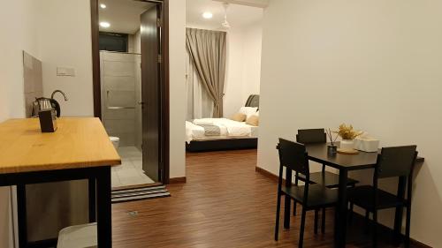 a kitchen with a table and a room with a bed at D'Bayu Homestay in Donggongon