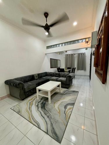 a living room with a couch and a table at Aster Homestay Telok Panglima Garang in Teluk Panglima Garang