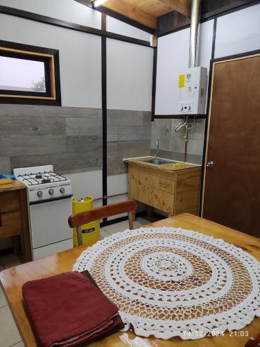 a kitchen with a table and a stove and a sink at RdA Apartment in Pichilemu