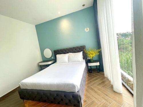 a bedroom with a bed and a blue wall at Sky View Memory Inn in Xuan An