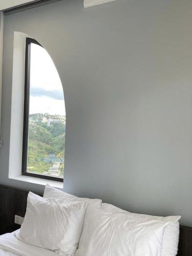 a bedroom with a window and a bed with white sheets at Sky View Memory Inn in Xuan An