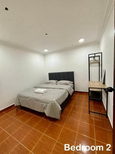 a bedroom with a bed and a table in it at Aster Homestay Telok Panglima Garang in Teluk Panglima Garang