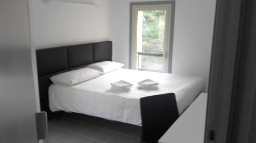 - une chambre avec un lit avec deux oreillers et une fenêtre dans l'établissement Le Relais de Monti, à Menton