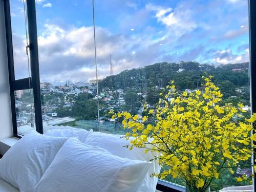 a bedroom with a bed and a window with yellow flowers at Sky View Memory Inn in Xuan An