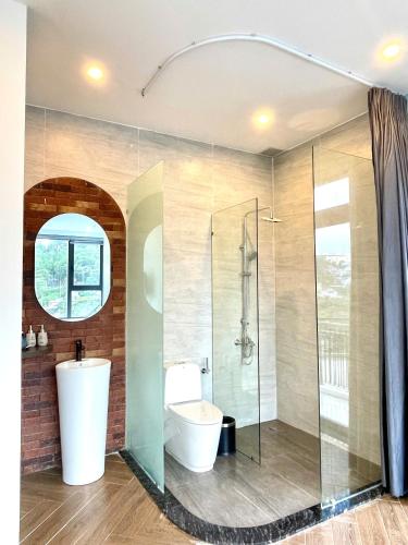 a bathroom with a toilet and a glass shower at Sky View Memory Inn in Xuan An