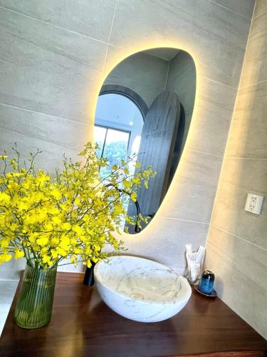a bathroom with a bowl and a mirror and flowers at Sky View Memory Inn in Xuan An