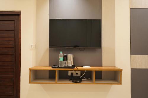a television on a wall with a wooden shelf at The Grand View in Baijnāth