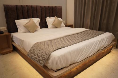a bedroom with a large bed with white sheets and pillows at The Grand View in Baijnāth