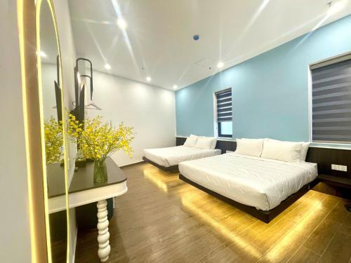 a bedroom with two beds and a table with flowers at Sky View Memory Inn in Xuan An