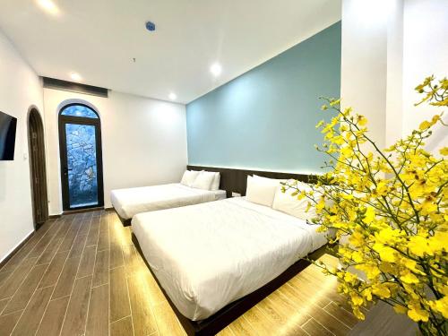 a bedroom with two beds and a plant at Sky View Memory Inn in Xuan An