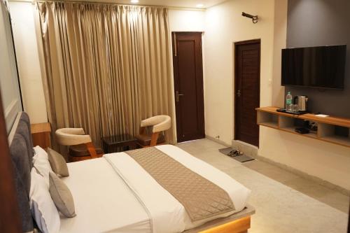 a hotel room with a bed and a flat screen tv at The Grand View in Baijnāth