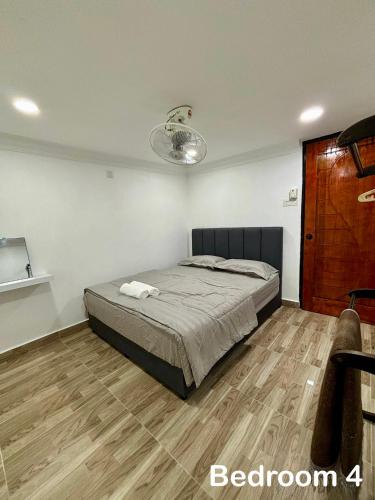 a bedroom with a bed and a wooden floor at Aster Homestay Telok Panglima Garang in Teluk Panglima Garang
