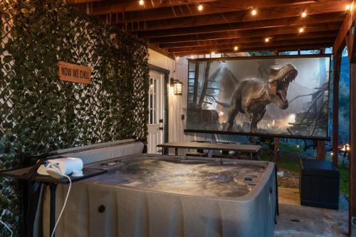 a room with a large picture of a dinosaur on the wall at Sequoia's Dream with Mountain View, Spa, Heated Floor, Bar, Cinema! in Oakhurst