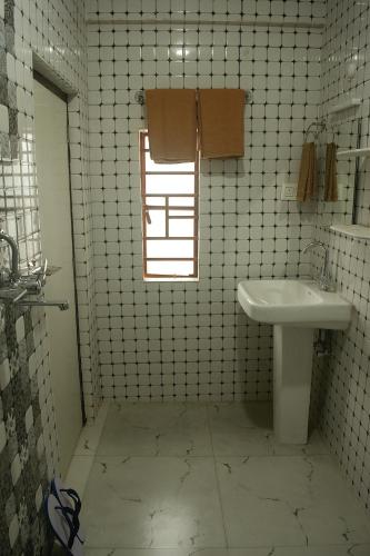 a small bathroom with a sink and a window at Norchuk Homestay in Jālāpahār