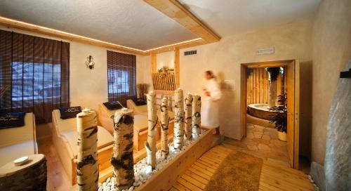 a woman is walking through a room with a chessboard at Naturhotel Sonnenhof in Chiusa