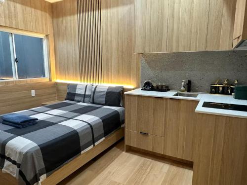 a small kitchen with a bed and a sink at Oak Haven Sydney Suites in Sydney