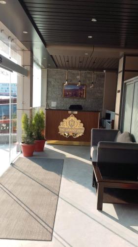 a lobby with a couch and a desk in a building at The Grand View in Baijnāth