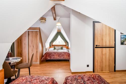a bedroom with a bed and a table and chairs at Cicha Woda 300 m od Gorący Potok i Termy Szaflary in Szaflary