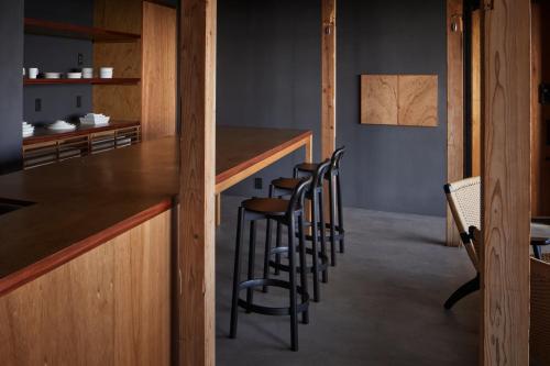 a group of stools sitting at a bar in a room at GOTO island ROKGOUTEI五島列島福江島のモダンな一棟貸ヴィラ in Goto