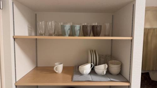 a shelf with several glass vases and bowls on it at STAY Moiwayama in Sapporo