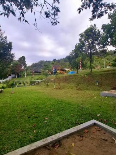 a park with a field of green grass and trees at Kebun Teduh Sukaharja Cijeruk Bogor in Palasari