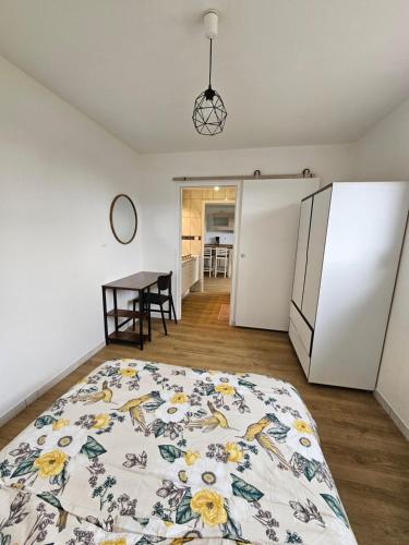 - une chambre avec un lit, un réfrigérateur et une table dans l'établissement Les Bruyères, à Remiremont