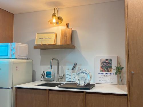 a kitchen with a sink and a refrigerator at Gurida Bupyeong in Incheon