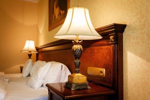 a lamp on a table next to a bed at Aqua Marina in Karlovy Vary