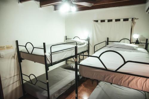 two bunk beds in a room with a ceiling at Mai Ke Kai Surf House in Tamarindo