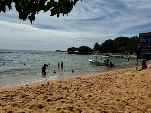 a group of people in the water at a beach at Brinkhouse Guesthouse , Unawatuna beach in Unawatuna