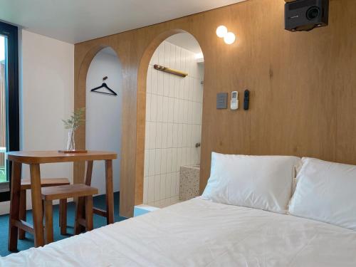 a bedroom with a bed and a table and a shower at Gurida Bupyeong in Incheon