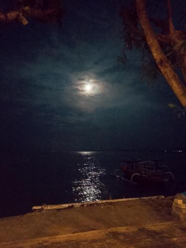 a full moon over the water at night at Gili Gede Homestay in Gili Gede
