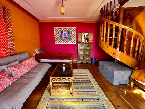 a living room with a couch and a staircase at Joy Source Resort in Kathmandu