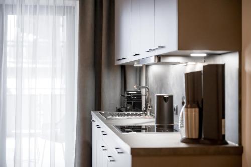 a kitchen with white cabinets and a stove top oven at Apart Natur in Sölden