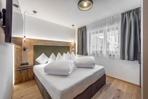 a bedroom with a large bed with white pillows at Apart Natur in Sölden