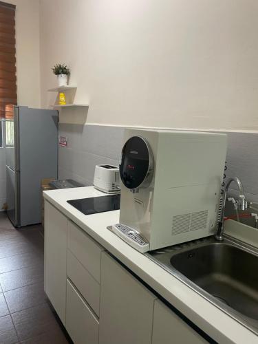 a kitchen with a sink and a microwave at Luxury, Affordable and Spacious Private Villa with Swimming Pool & Jacuzzi for 20 plus ppl Cyberjaya in Cyberjaya