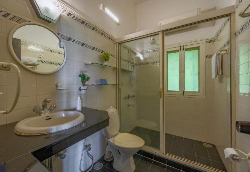 a bathroom with a sink and a toilet and a shower at SaffronStays Sea Sparkle in Adi