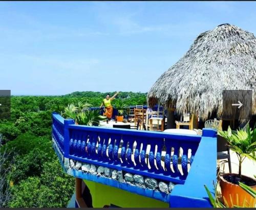 a blue fence with a straw umbrella on top of a restaurant at Hayley's Paradise Limited in Little Bay