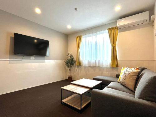 a living room with a couch and a tv at Casa Stella 8 by Liaison カーサステラ8 byリエゾン in Osaka