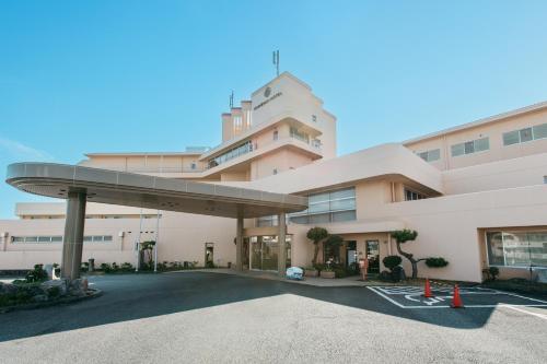 a building with a parking lot in front of it at KAMENOI HOTEL Kii-Tanabe in Tanabe