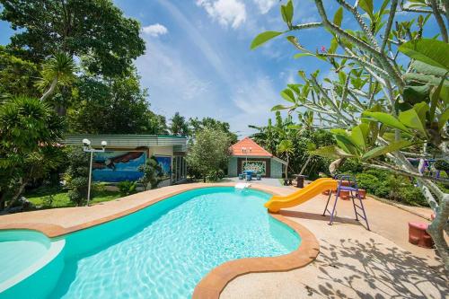 a swimming pool with a slide in a backyard at Tontarn Resort and Spa in Khanom