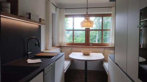 a kitchen with a small table and a window at Fewo Sonntagshorn in Ruhpolding