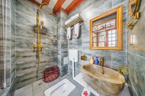 une salle de bain avec une grande baignoire et un lavabo dans l'établissement Dali Classical Rosewood Boutique Inn, à Dali