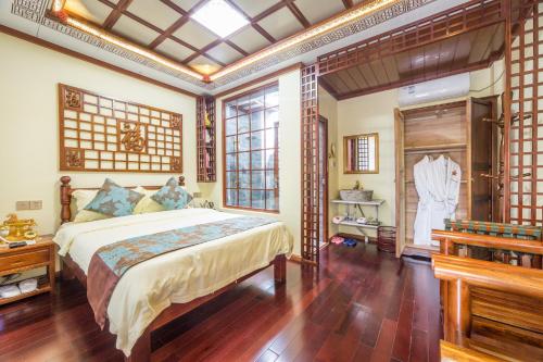 une chambre avec un grand lit dans une pièce dans l'établissement Dali Classical Rosewood Boutique Inn, à Dali