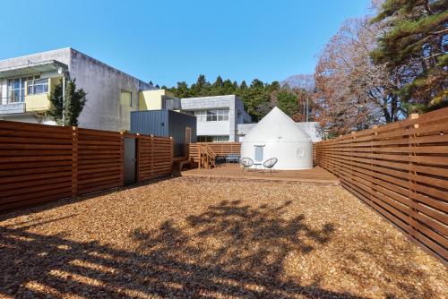a backyard with a fence and a white shed at ReSchool Nasu Glamp in Nasu