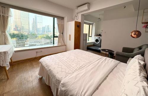 a bedroom with a white bed and a large window at 深圳LaCave公寓 in Shenzhen