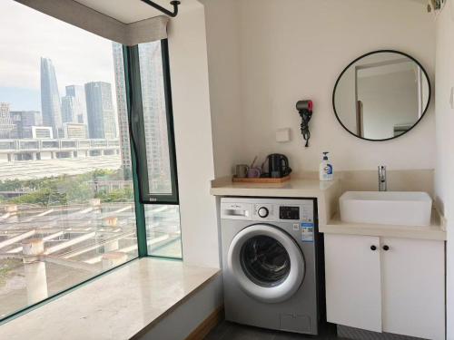 a bathroom with a washing machine and a mirror at 深圳LaCave公寓 in Shenzhen