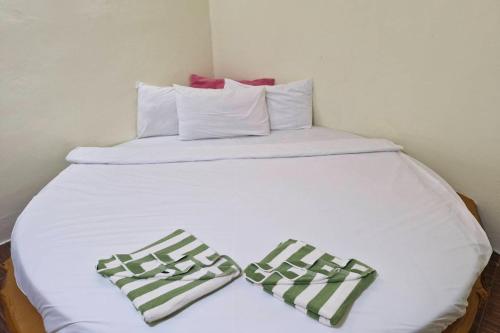 a white bed with two pillows on top of it at Tontarn Resort and Spa in Khanom