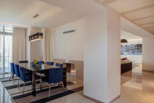 a dining room with a table and blue chairs at The Abdali Boulevard Hotel in Amman
